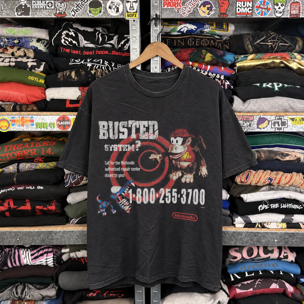 95 Nintendo Busted Systems Rare Employee Vintage Washed Black T-Shirt — off-body front on wooden hanger